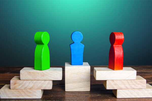 Groene en rode pion met blauwe mediator ertussen als symbool voor hulp en bemiddeling bij ontslag