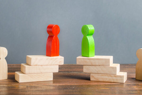 Rode en groene pionnen tegenover elkaar als symbool voor onderhandelingen bij een vaststellingsovereenkomst